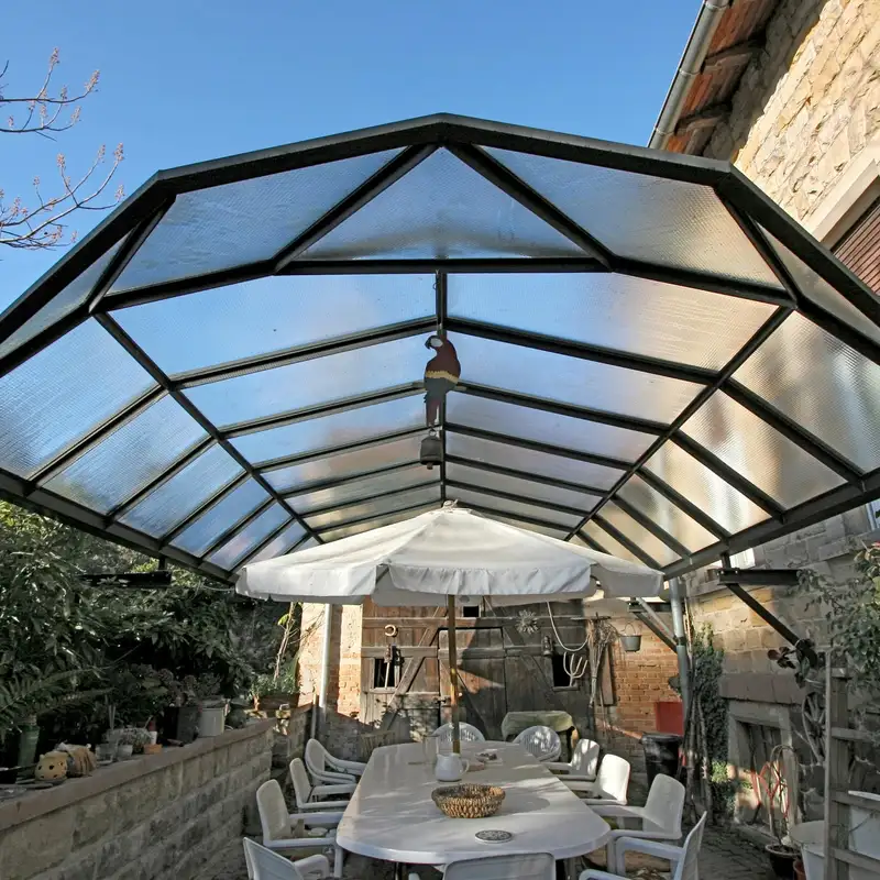 Zu sehen ist eine individuell geplante Überdachung aus Stahl und Glas – passgenau gefertigt und perfekt in den Bestand integriert. Die Kombination aus klarer Struktur und transparenter Fläche sorgt für Licht, Schutz und ein zeitloses Gesamtbild. Ideal für geschützte Außenbereiche mit Charakter.